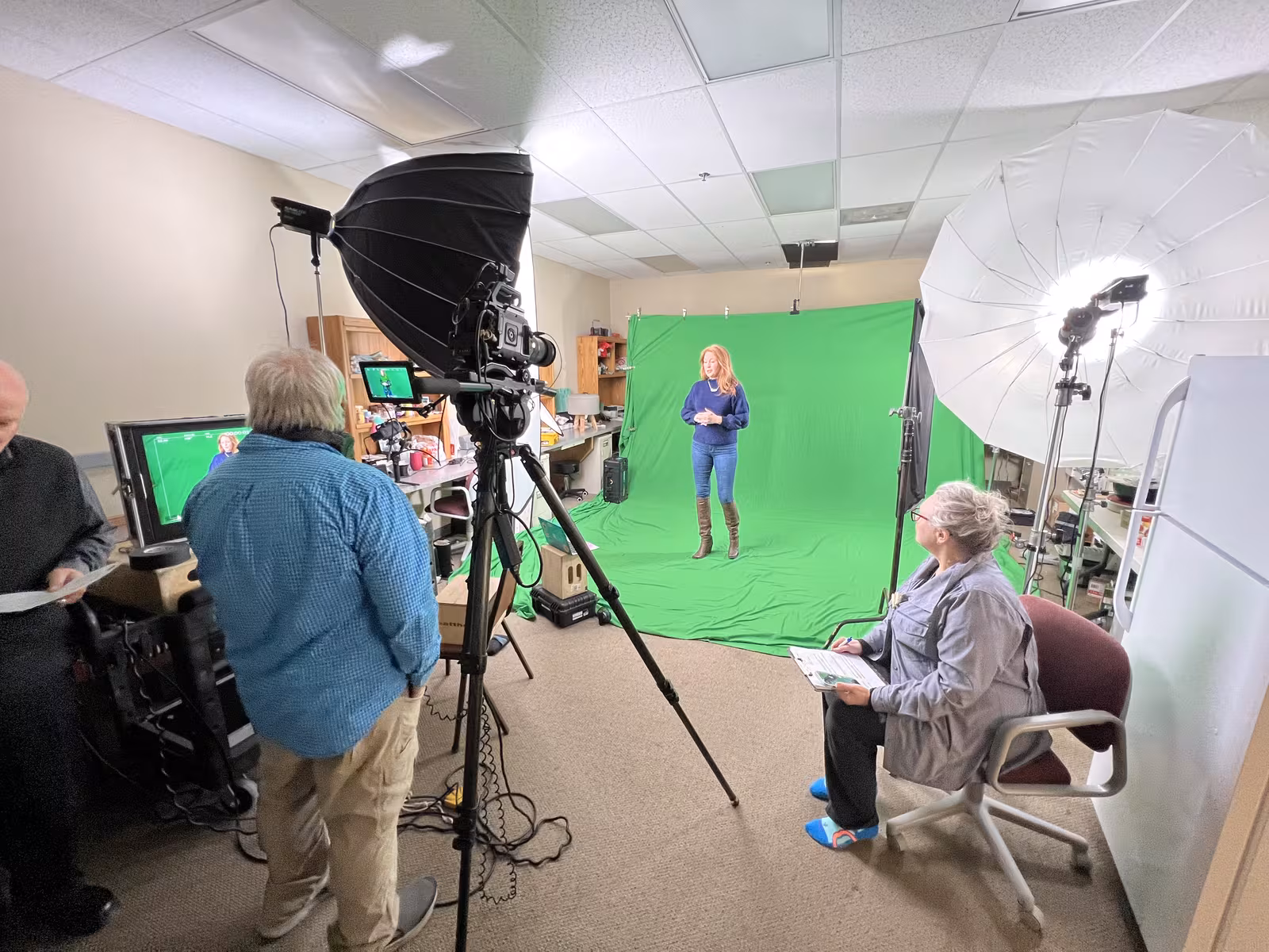 Green screen studio setup with softbox lighting during an on-camera shoot