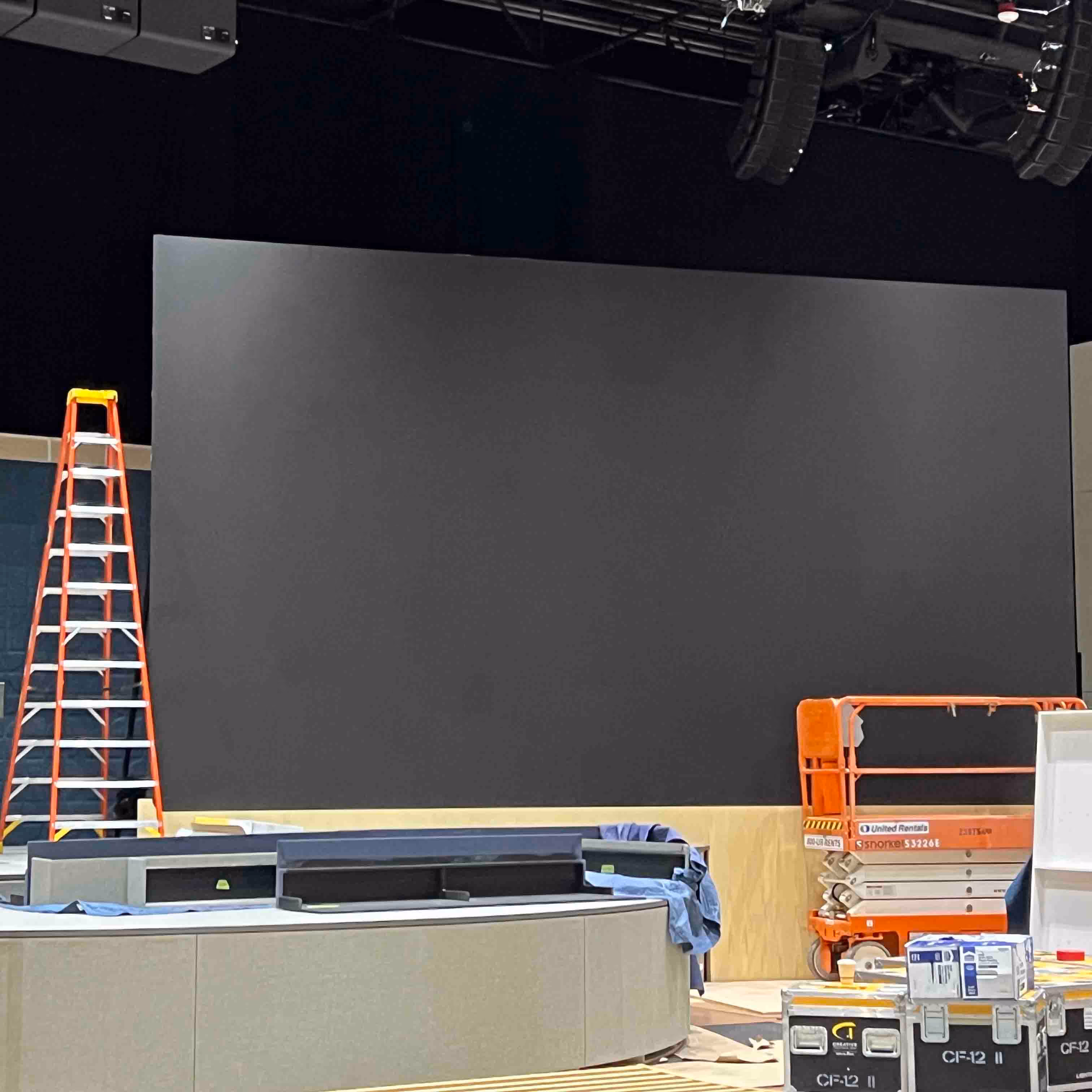 Indoor construction area with equipment cases and a scissor lift